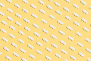 white capsules on yellow background