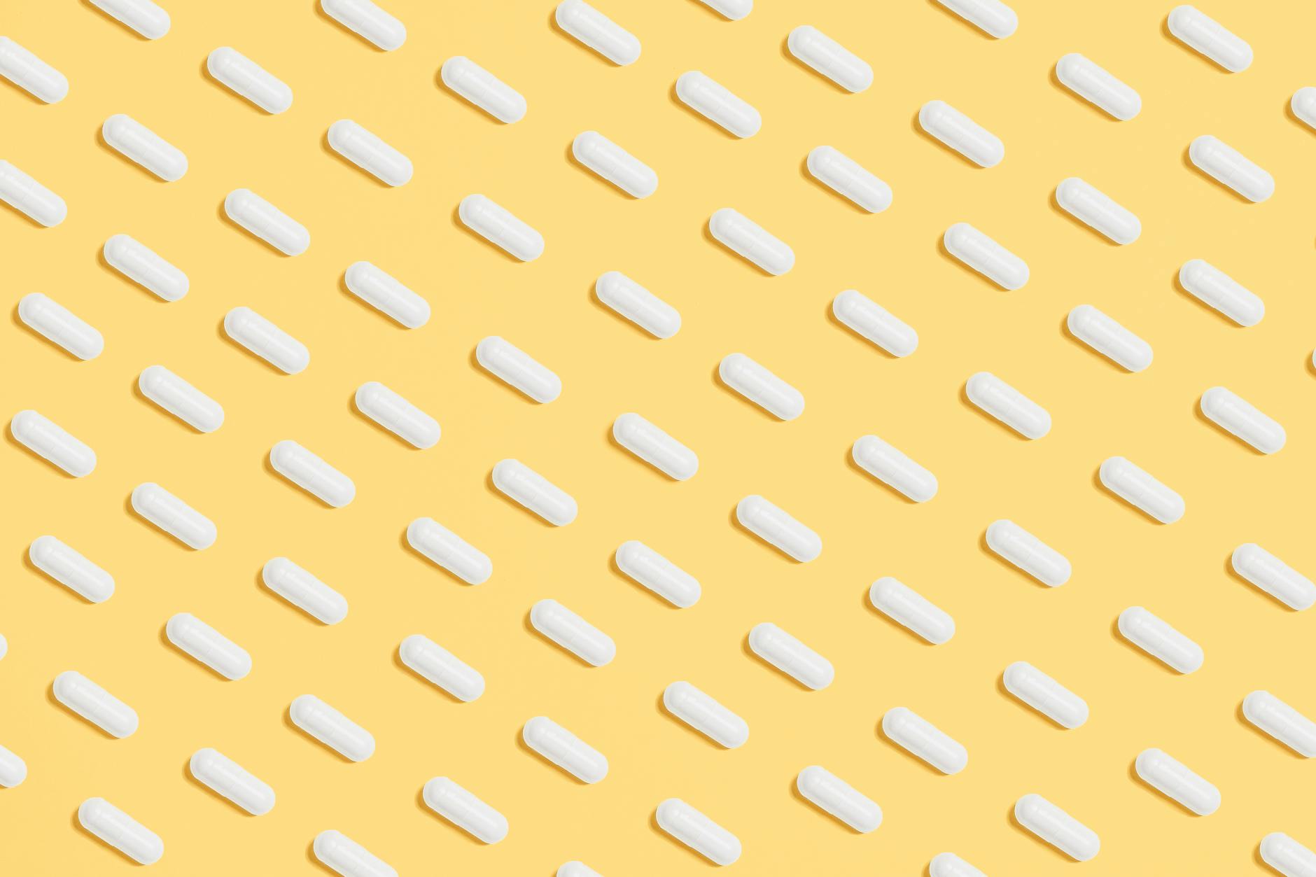 white capsules on yellow background